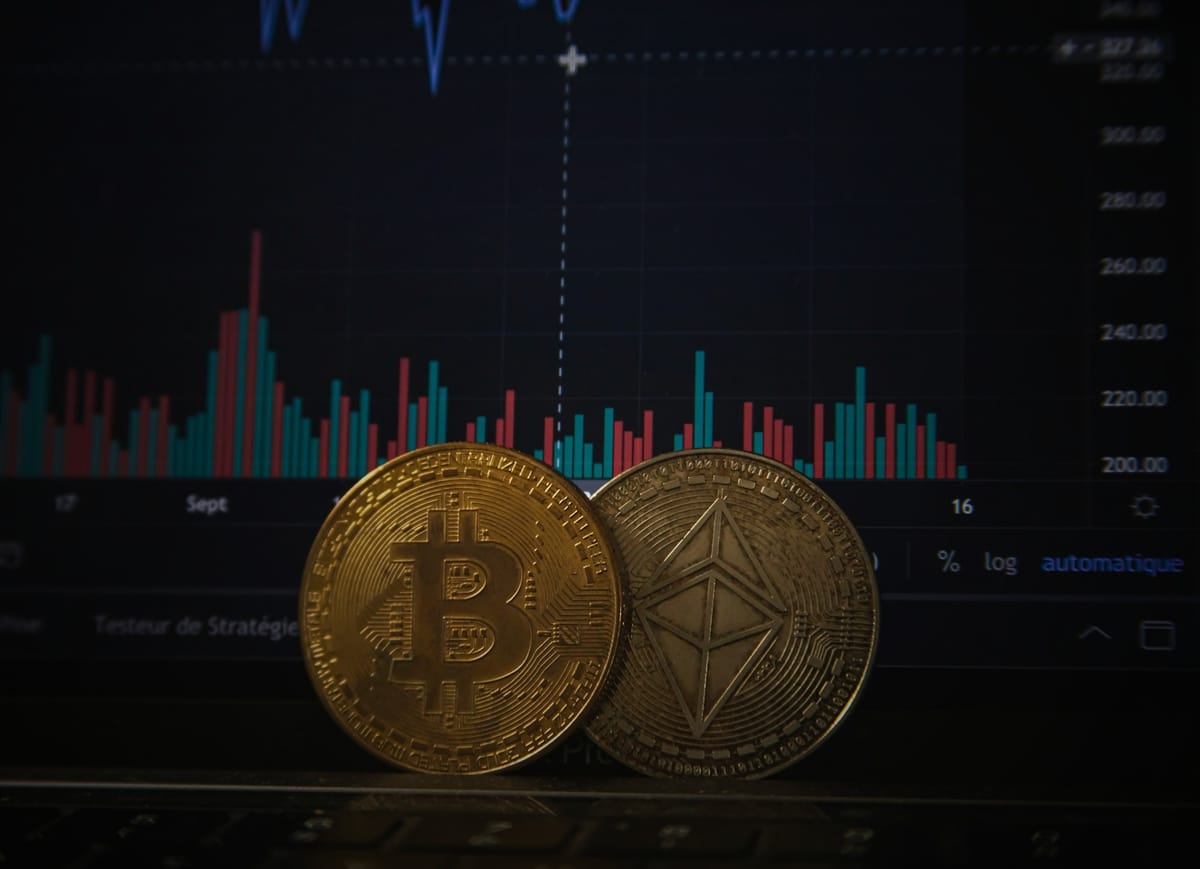 2 bitcoins in front of a laptop screen